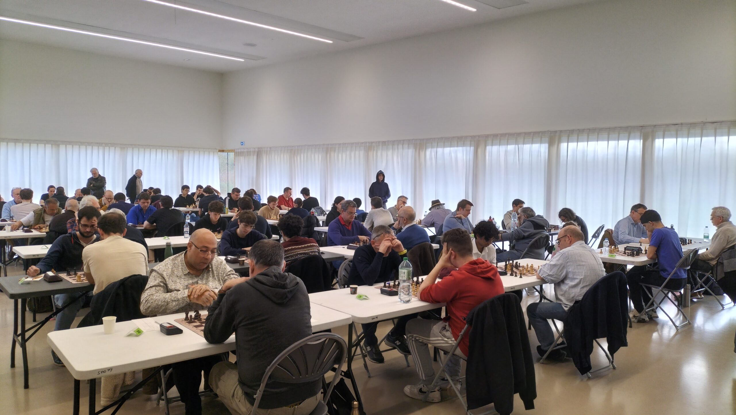 Salle des Mares Yvon à Saint‑Michel‑sur‑Orge pendant un open d’échecs, rangées de tables et échiquiers.